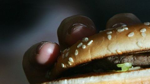 LONDON - JULY 12: In this photo illustration a lady eats a beefburger on July 12, 2007 in London, England. Government advisors are considering plans for a fat tax on foods high in fat to try to help tackle the fight against obesity. (Photo illustration by Cate Gillon/Getty Images)
