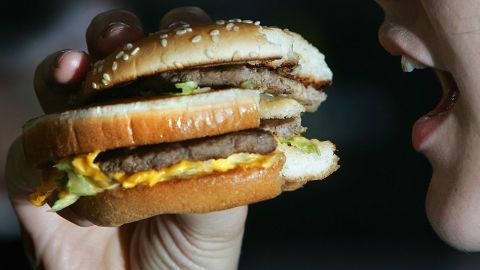 LONDON - JULY 12: In this photo illustration a lady eats a beefburger on July 12, 2007 in London, England. Government advisors are considering plans for a fat tax on foods high in fat to try to help tackle the fight against obesity. (Photo illustration by Cate Gillon/Getty Images)