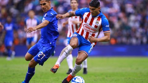 José Madueña disputando un balón con Alan Pulido.