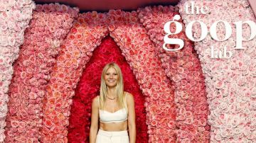 Gwyneth Paltrow enmarcada por una representación de una vulva hecha con rosas para el lanzamiento de su serie The Goop Lab.