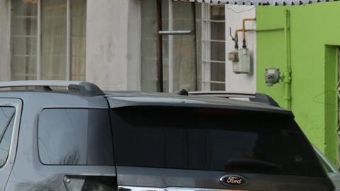 El comerciante iba saliendo de su casa.