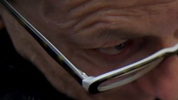 Un hombre observa atentamente un disco de vinil antes de comprarlo