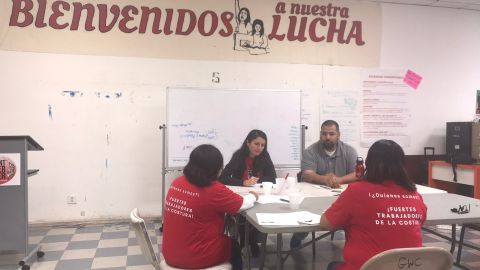 Daisy González y Alejandro Sánchez, organizadores de Centro de Trabajadores de Costura, hablan con dos costureras. (Iliana Salguero)