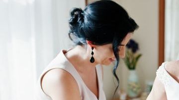 2_Bridesmaids-helping-gorgeous-bride-to-dress-up-and-get-ready-for-her-wedding-ceremony