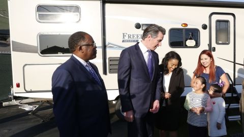 Gavin Newsom y otros funcionarios con una de las familias en Safe Landing for Families-Broadway.