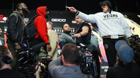 Tyson Fury (der.) amenaza a Deontay Wilder antes de la conferencia de prensa.
