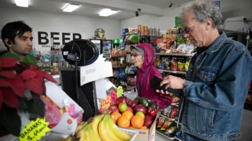 Dolores Helman, de 93 años, compra alimentos con su hijo Elliot Helman de 64 años.