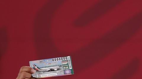AMLO muestra su billete para la rifa del avión presiencial.