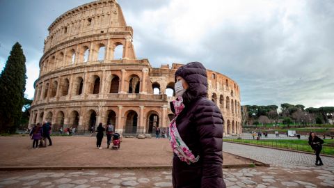 Turista con mascarilla cerca del Coliseo en Roma.