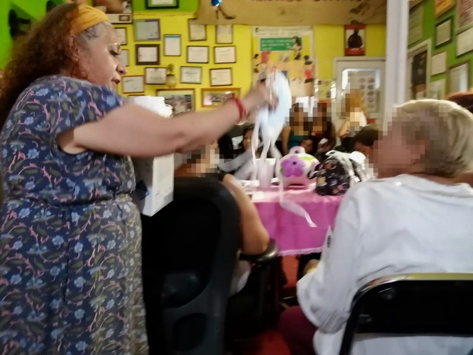 Una activista entrega cubrebocas a una trabajadora del sexo de la tercera edad