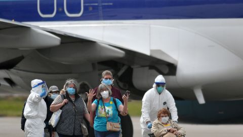 El personal médico ayuda a cargar pasajeros del crucero Grand Princess en aviones en el Aeropuerto Internacional de Oakland en Oakland.