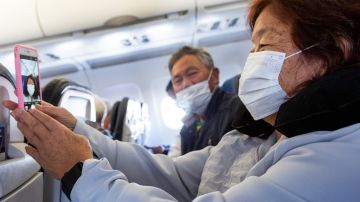 Pasajeros usan mascarillas durante un vuelo para protegerse de la pandemia.