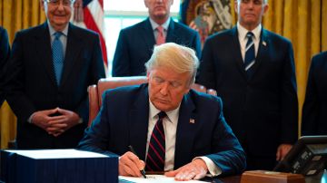 El presidente Trump firma la Ley CARES de estímulo económico.