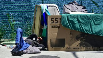 Una persona sin hogar acostada en una calle de Los Ángeles.