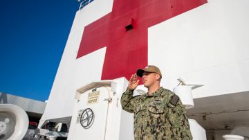 Un oficial de la Marina haciendo un saludo a la bandera a bordo del USNS Mercy.