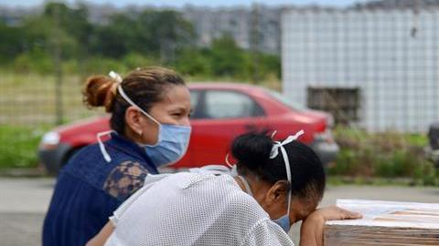 Mujer llora ante el ataúd de su familiar.
