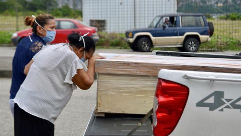 Mujer llora ante el ataúd de su familiar.