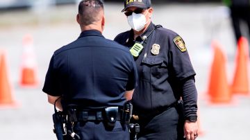 Un oficial del Departamento de Bomberos del Condado de Los Ángeles conversa con un oficial de policía.