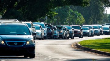 Decenas de conductores esperan en fila para recoger suministros en los Estados Unidos.