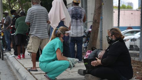 Una enfermera junto a una persona sin hogar en el centro de Miami.