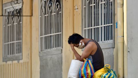 Un hombre espera afuera de una residencia en Guayaquil.