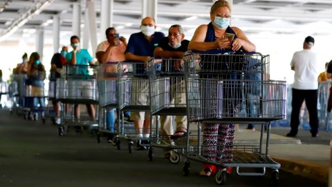 Personas hacen fila para entrar a un supermercado en San Juan (Puerto Rico).