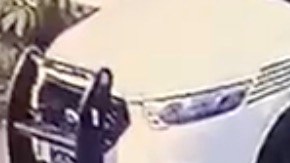 Captura del momento en que el doctor es esposado por el agente de policía.