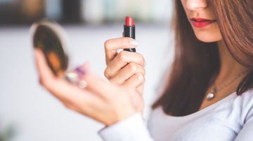 woman-with-brown-hair-doing-lipstick-and-holding-little-6393