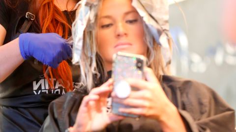 Vacaville (United States), 01/05/2020.- A customer uses her phone while having her hair styled by Cecily Clay, an employee of owner, Lia Rivera of Hairendipity Salon, after Rivera opened her business two days ago in defiance of the COVID-19 Stay-at-Home Order in Vacaville, California, USA, 30 April 2020. California Governor Gavin Newsom said hair salons fall under the state's third phase of reopening California businesses. California is currently in the first phase. Rivera is willing to risk a 1,000 US dollar fine, instead of losing thousands of dollars of staying closed. (Abierto, Estados Unidos) EFE/EPA/JOHN G. MABANGLO