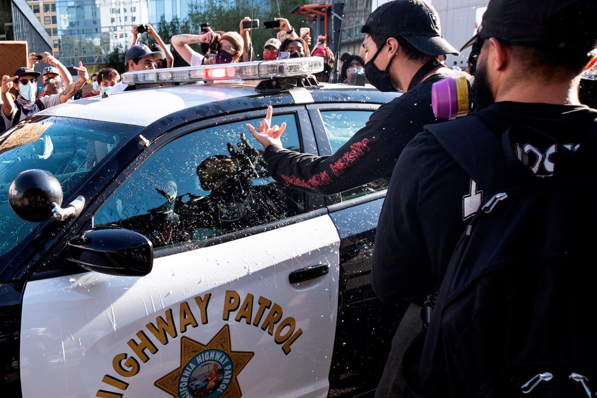 Un manifestante ataca a una patrulla del CHP en las protestas de Los Ángeles.