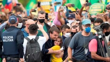 El presidente de Brasil, Jair Bolsonaro, saluda a una niña este domingo.
