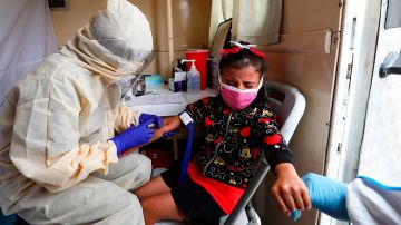 Un médico aplica una prueba de detección de COVID-19 a una niña en Pichincha.