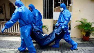 AME7763. GUAYAQUIL (ECUADOR), 05/05/2020.- Fotografía de archivo fechada el pasado 17 de abril de 2020 en la que miembros de la Fuerza de Tarea Conjunta (FTC) recolectan cadáveres en medio de la pandemia de la COVID-19 en Guayaquil (Ecuador). La Fiscalía de Ecuador ha abierto una investigación por la compra a sobreprecio para ese hospital de bolsas de cadáveres a 148 dólares, en lugar de los 12 que suelen costar en el mercado. Es la nueva vuelta de tuerca de la telenovela que salpica una y otra vez a la ciudad ecuatoriana más castigada por el COVID-19, Guayaquil, donde los escándalos se reproducen desde hace dos meses poniendo en tela de juicio la gestión gubernamental de la crisis. El nuevo caso de presunta corrupción, por el que hay cuatro personas bajo arresto preventivo, está relacionado, esta vez, con sobreprecios en la compra de insumos médicos en un hospital público, y entre ellos 4.000 bolsas para la recogida de cadáveres. EFE/ Mauricio Torres