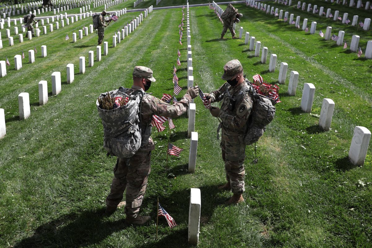 Soldados del 3er Regimiento de Infantería, "Old Guard", colocan banderas en cada tumba en el Cementerio de Arlington.