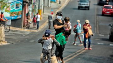 Una familia pide ayuda económica para comprar alimentos en una calle de Tegucigalpa, este 13 de mayo de 2020. EFE/Gustavo Amador