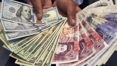 A cashier displays multiple denomination US dollar and British pound Sterling bank notes for a photograph inside a currency exchange store in central London on October 4, 2016. 
The pound slumped to a 31-year low against the dollar Tuesday, sinking to $1.2740 -- its lowest level since 1985 -- on concerns over the timing and terms of Britain's planned exit from the European Union, traders said. Britain's currency also struck a fresh three-year low point against the euro, while the drops helped pushed London's benchmark FTSE 100 stocks index up to a 16-month high beyond 7,000 points at the open. / AFP / NIKLAS HALLE'N        (Photo credit should read NIKLAS HALLE'N/AFP via Getty Images)