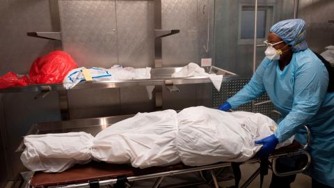 Transporter Morgan Dean-McMillan prepares the body of a COVID-19 victim at a morgue in Montgomery county, Maryland on April 17, 2020. - In the past three weeks the owners of the Maryland Cremation services, Dorota Marshall and her husband Sean, have seen an estimated increase of 30% more cases because of the novel coronavirus pandemic. Because of the pandemic and the risks, they can no longer allow viewings, but only identification visits, while families must pick up the ashes outside the office in their cars. They recently agreed to see if they could help a New York crematorium, which is backed up with overflow, with cremations. (Photo by ANDREW CABALLERO-REYNOLDS / AFP) (Photo by ANDREW CABALLERO-REYNOLDS/AFP via Getty Images)