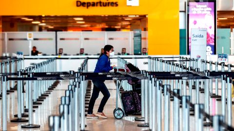 Una mujer usa máscaras como precaución contra la propagación del nuevo coronavirus COVID-19 en el Aeropuerto Internacional de Sao Paulo.