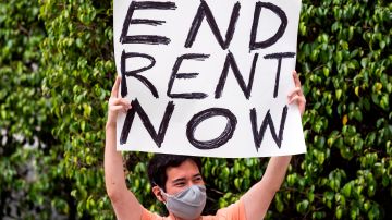 Un manifestante en L.A. despliega un mensaje sobre el pago de la renta.