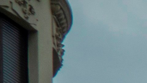 Varios peatones cruzan una calle delante de una bandera que ondea a media asta en memoria de las víctimas de coronavirus en Santander. EFE/Román G. Aguilera/Archivo