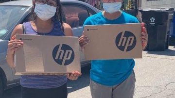 Yesenia Velez (der.) y su hermana Maria Velez, recibieron computadoras portátiles el miércoles. (InnerCity Struggle)