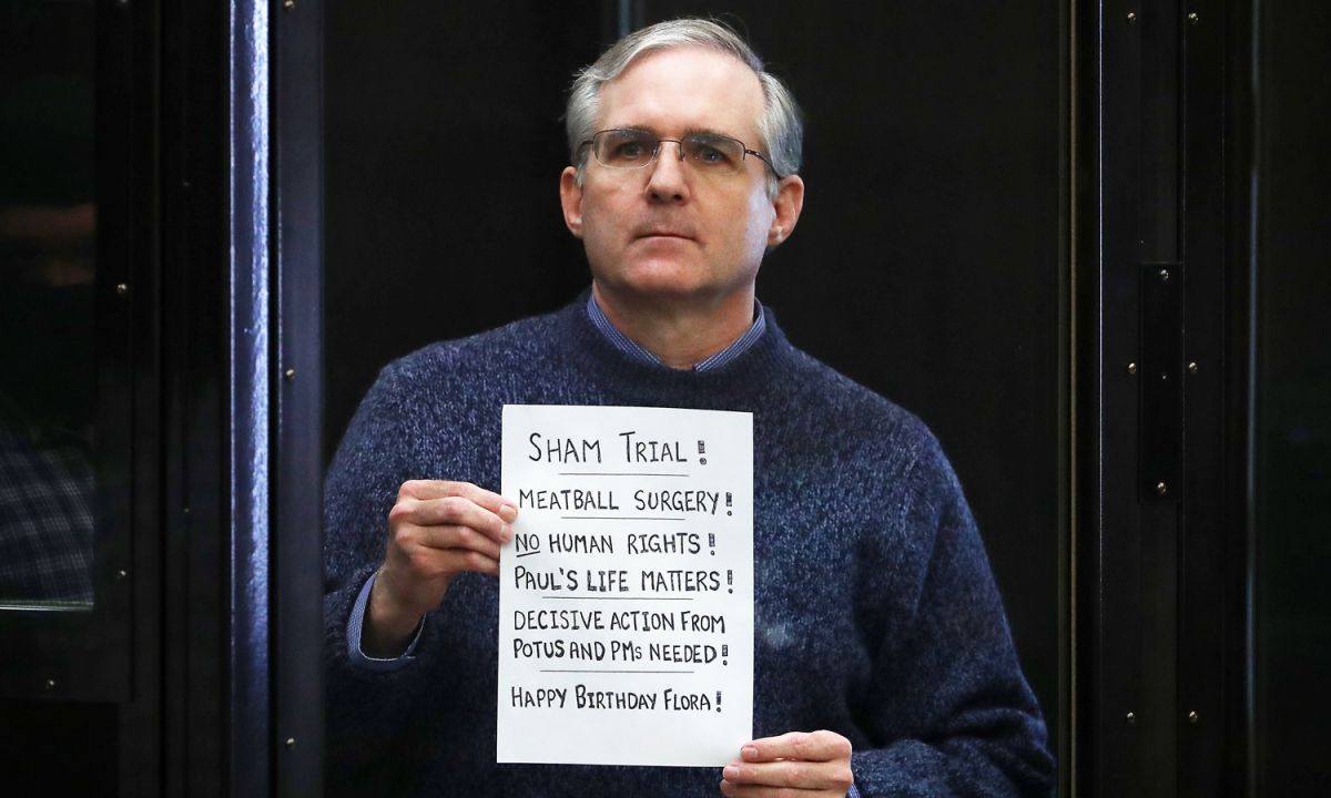 Paul Whelan sostiene un cartel al final de su juicio.