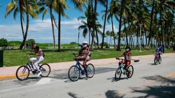 Ciclistas paseando en la emblemática avenida de Ocean Drive en Miami Beach.