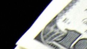 A money changer holds a wad of USD bills