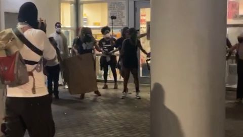 Manifestantes frente a la entrada de CVS en Miami para impedir los actos vandálicos.