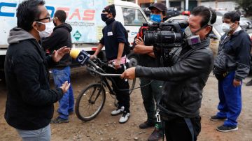 LIM01. LIMA (PERÚ), 03/05/2020. Periodistas trabajan cubriendo la pandemia de coronavirus, este miércoles en las calles de Lima (Perú). Al menos veinte periodistas muertos y más de un centenar de enfermos es el saldo que ha dejado en Perú hasta el momento el paso de la COVID-19, unas cifras desoladoras que dejan en evidencia la cruda realidad del trabajo periodístico en el país andino. EFE/Paolo Aguilar