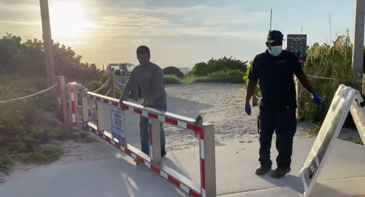 Empleados de la ciudad despejaban los accesos a la playa de Miami Beach para que los residentes y turistas puedan volver a entrar.