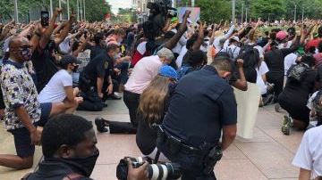 El jefe de la Policía de Houston Art Acevedo (centro) hincado en una de las manifestaciones.