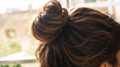 Mujer escribe nuevos objetivos personales y hábitos para mejorar su bienestar y estilo de vida