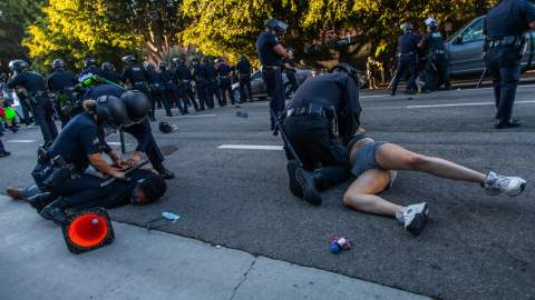 La policía arrojó contra el suelo a un hombre y a una mujer.